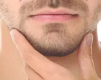 A man is grooming his beard with his hand.